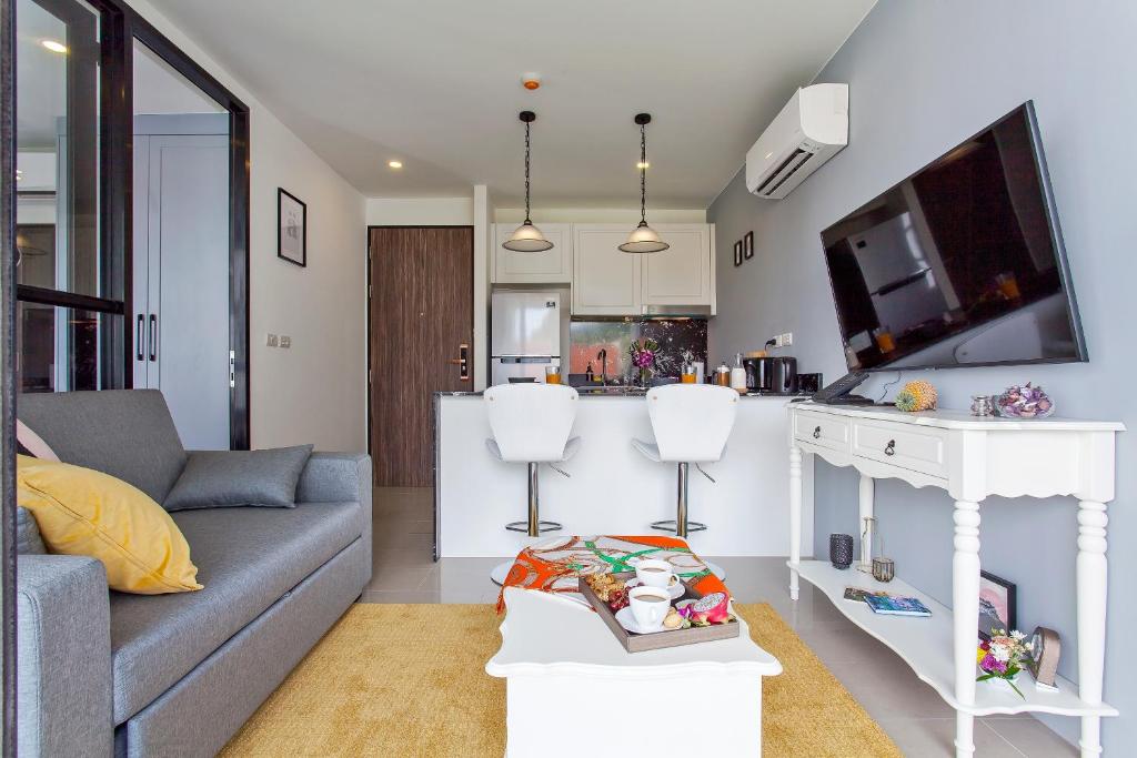 苏林海滩Palmyrah Surin Apartments by Beringela的带沙发的客厅和厨房