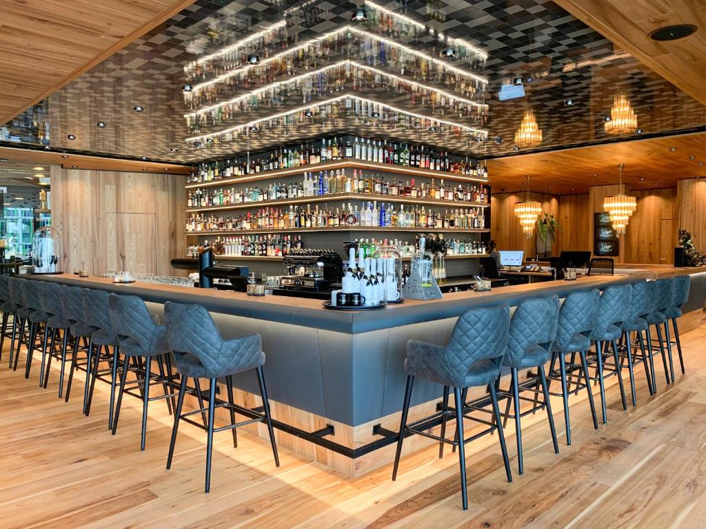丁克尔斯比尔Meiser Design Hotel的餐厅内带蓝色酒吧凳的酒吧