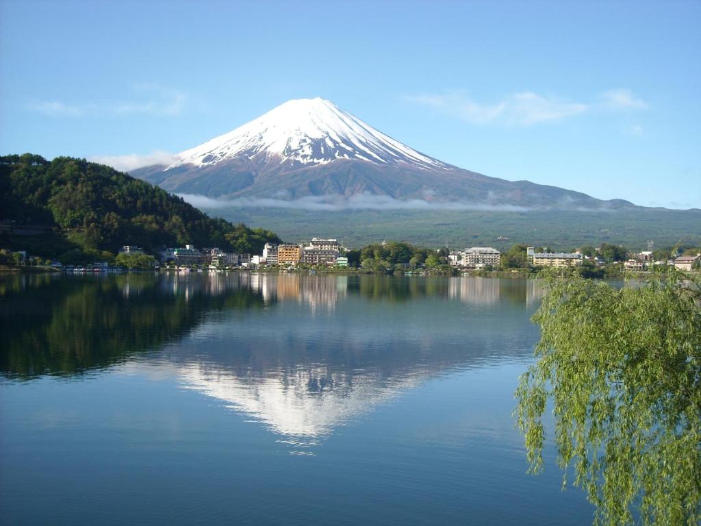 富士河口湖富之湖酒店 的一座湖中的山峰反射,有城镇和建筑