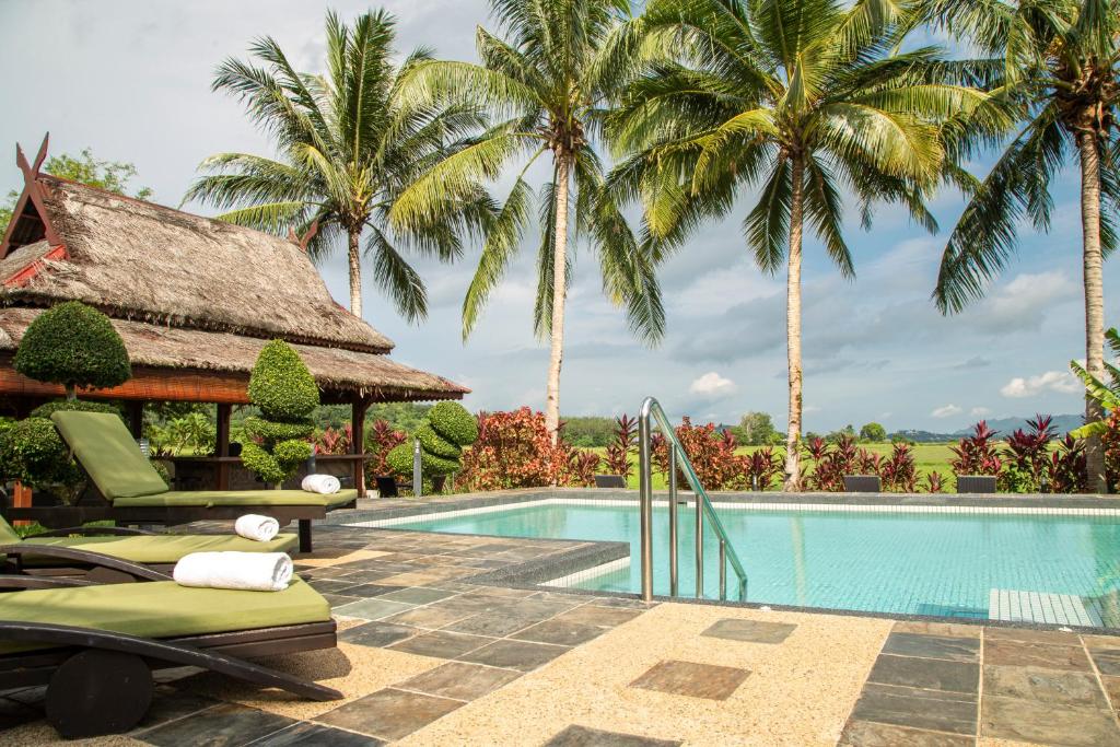 巴东马士力日落山谷别墅的棕榈树环绕的度假村游泳池