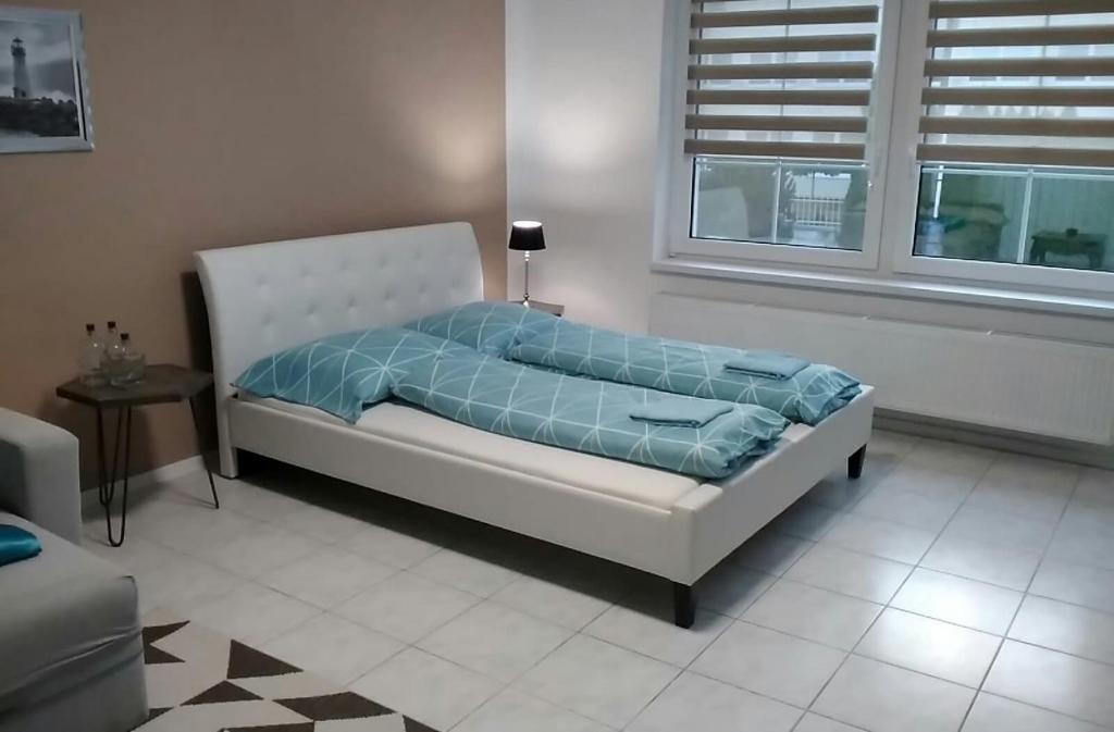 OslanySlnečný apartmánový dom Oslany的客房内的白色床和蓝色棉被