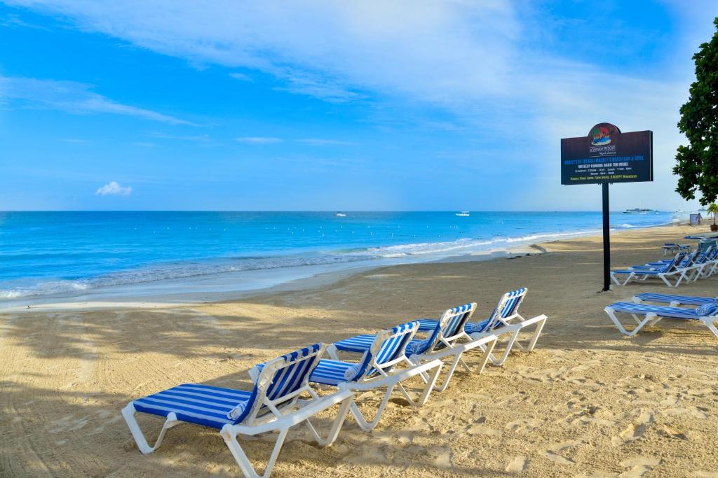 尼格瑞尔可可棕榈酒店的一群坐在海滩上的草坪椅