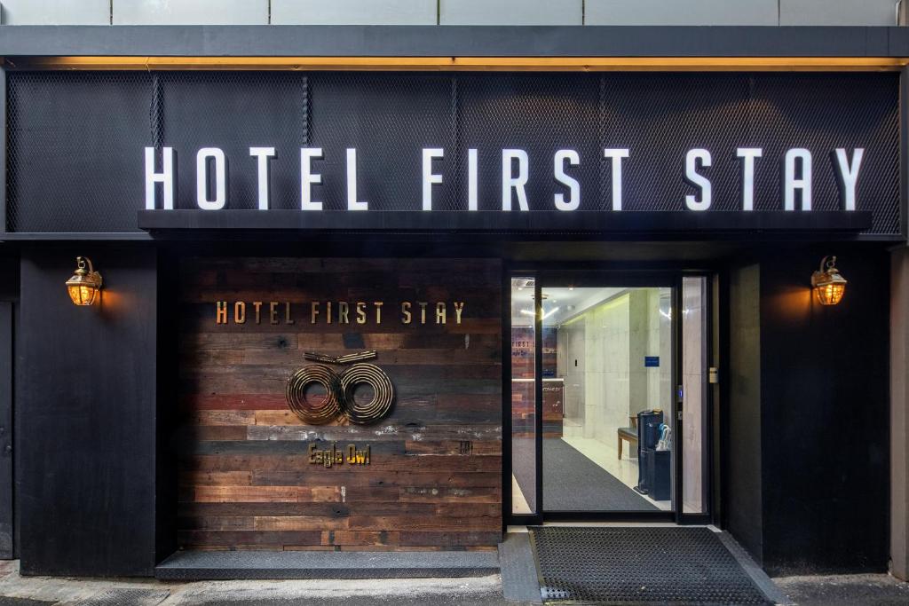 首尔Hotel Firststay Myeongdong的大楼前的酒店首期入住标志