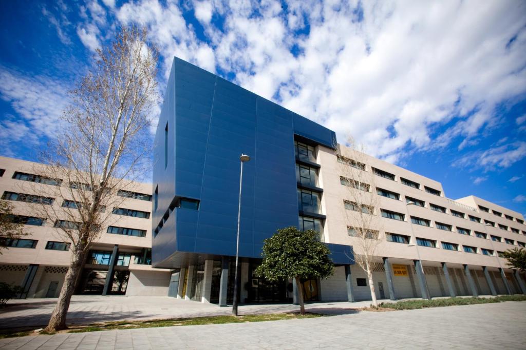 圣维森特德尔拉斯佩奇Villa Alojamiento y Congresos - Villa Universitaria的蓝色建筑的办公楼