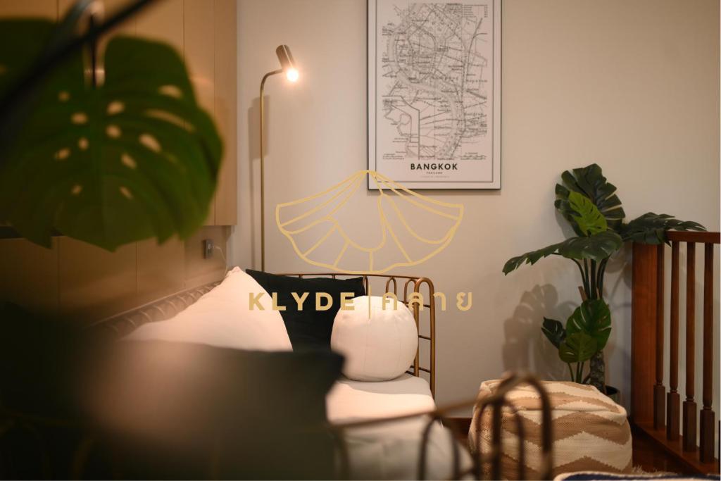 曼谷KLYDE Boutique - Chatuchak的一间设有床、植物和灯的房间