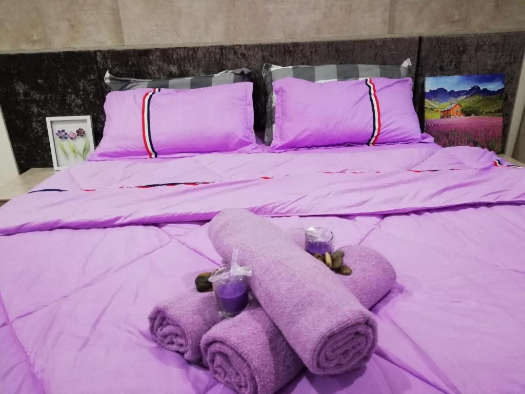 莎阿南LAVENDER Suite@I_CITY的紫色床,带两条毛巾和紫色枕头