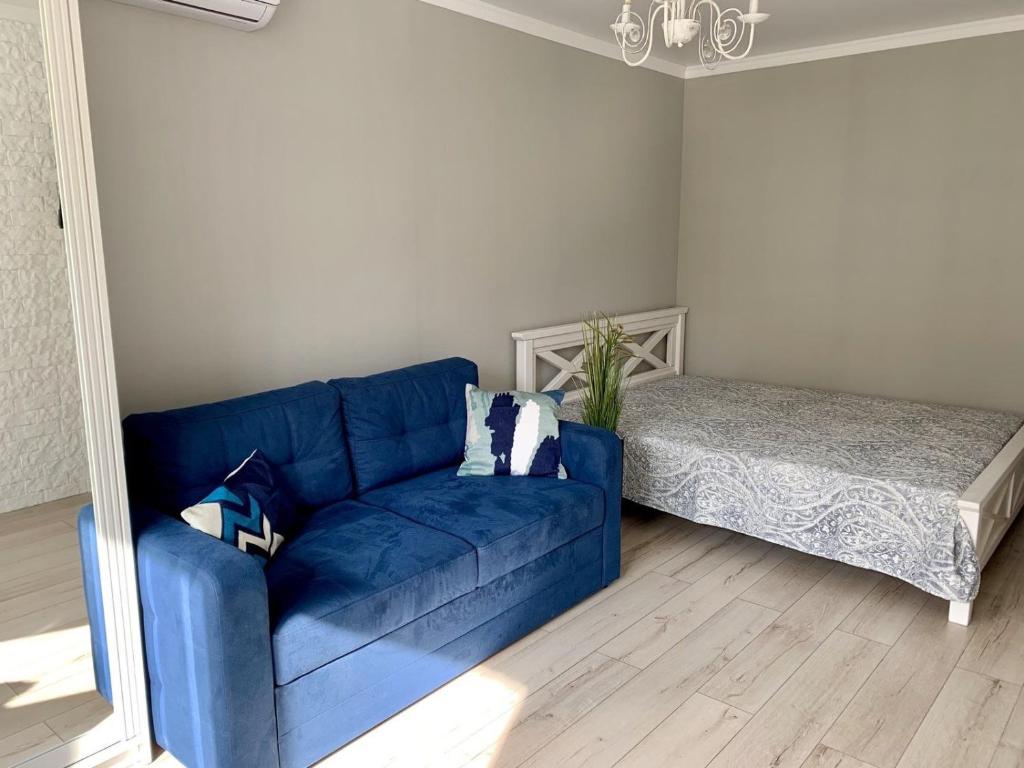 切尔尼戈夫Sisters apartment的客厅配有蓝色沙发,设有床