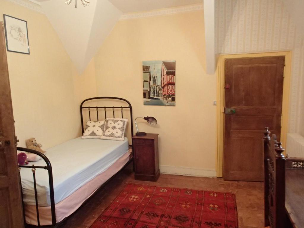 卢埃France Petit Château的卧室配有床、门和地毯