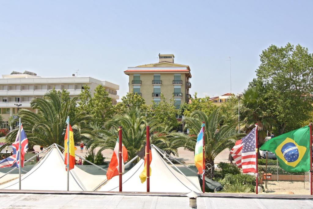 朱利亚诺瓦Hotel Cesare的建筑物前的一组旗帜