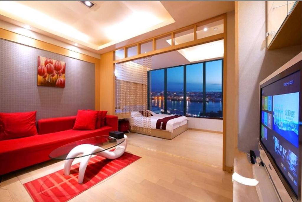 高雄85海角的客厅配有红色沙发和电视