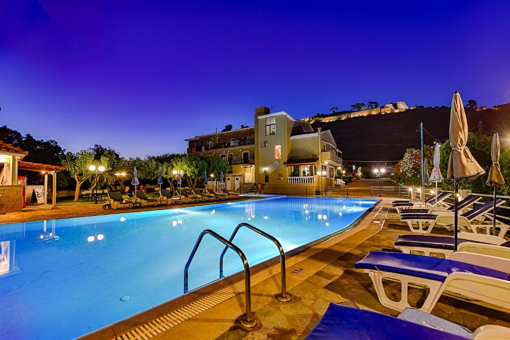 卡拉瓦杜斯伊奥尼斯酒店的一座带椅子的大型游泳池和一座建筑