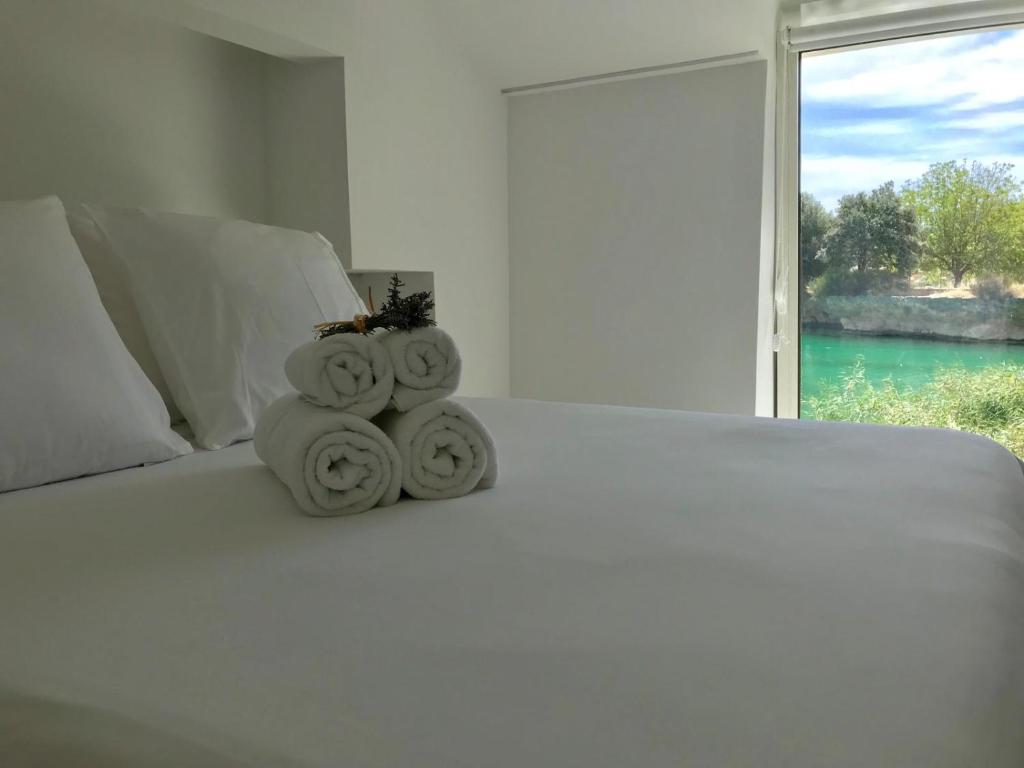 奥萨德蒙铁尔La Casita del Pescador的一张白色的床,上面有一堆毛巾