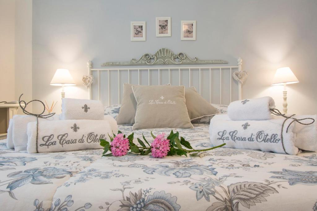 卡尔米尼亚诺B&B La Casa di Otello的一张带两个枕头的床,床上有鲜花