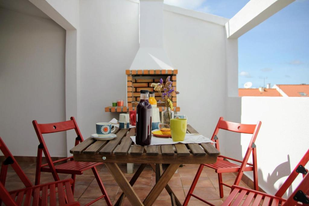 马夫拉Vila Mafra - Grill Terrace的桌椅和一瓶葡萄酒