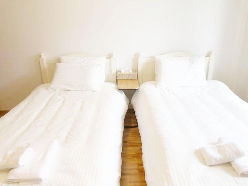 福冈ラ・フィットヤマト103的配有白色床单的客房内的两张床