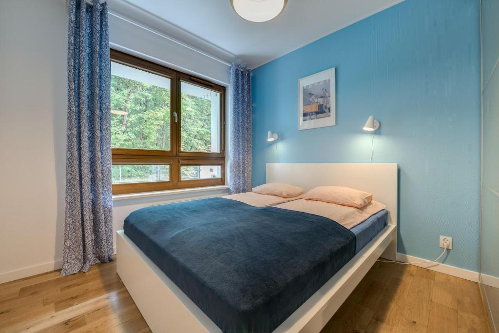 索波特Aquarius & FREE PARKING的一间卧室配有一张蓝色墙壁的床和一扇窗户