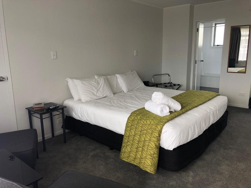 陶朗加阿姆拜塞德汽车旅馆的一间卧室配有一张大床和毛巾