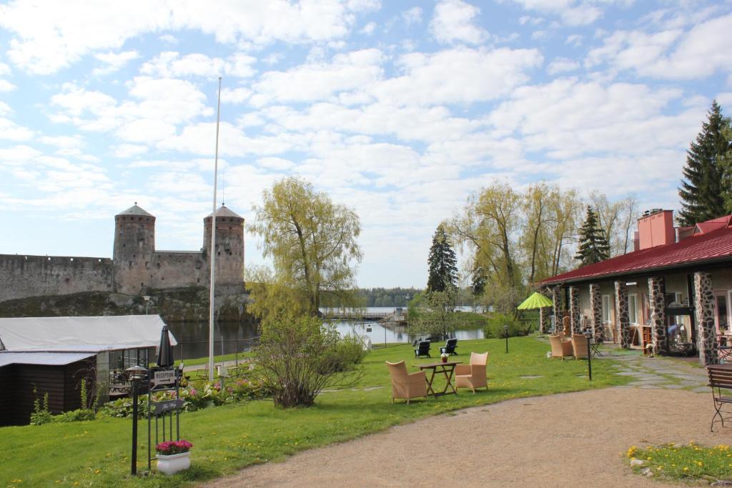 萨翁林纳罗西兰塔旅舍的一座毗邻湖泊和城堡的建筑