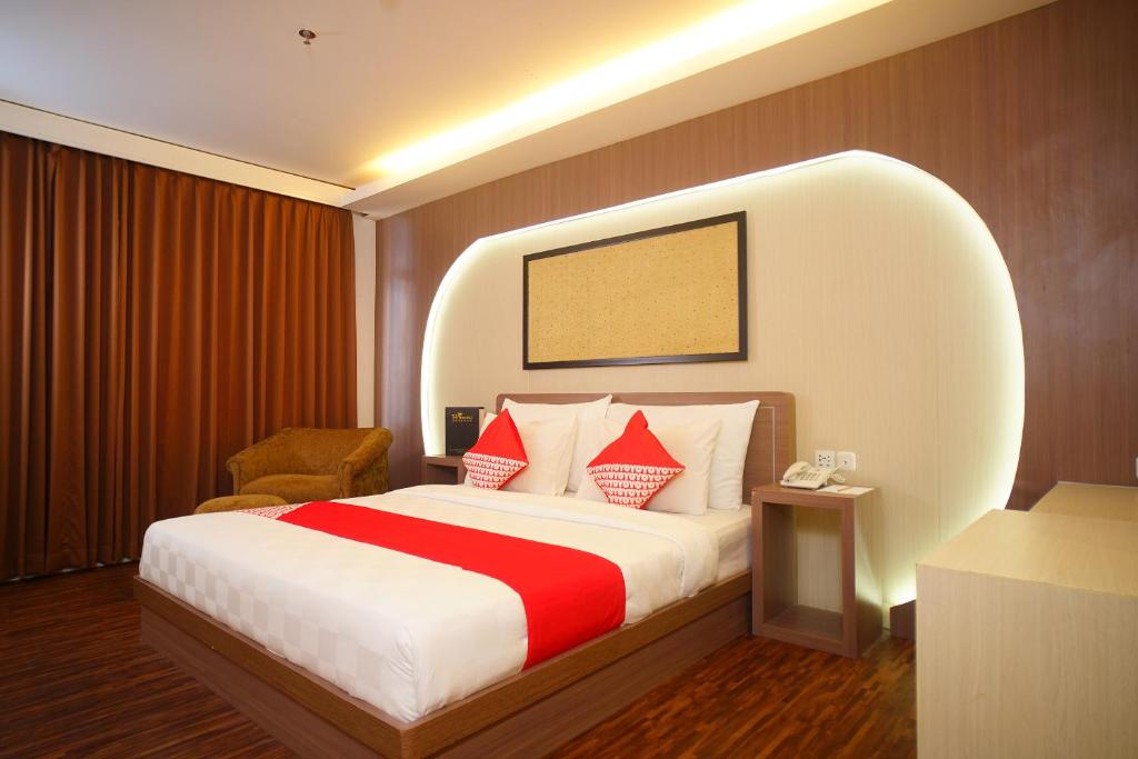 巨港SUPER OYO Collection O 166 Hotel Princess的酒店的客房 - 带红色和白色枕头的床
