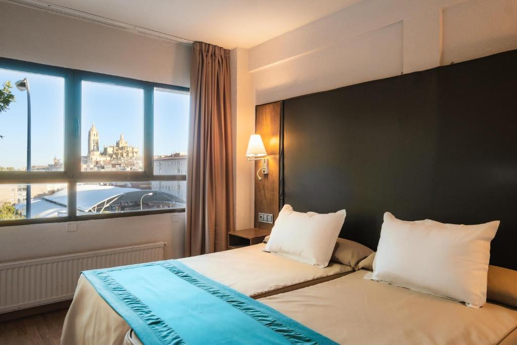 塞哥维亚科雷希多酒店的酒店客房设有一张床和一个大窗户