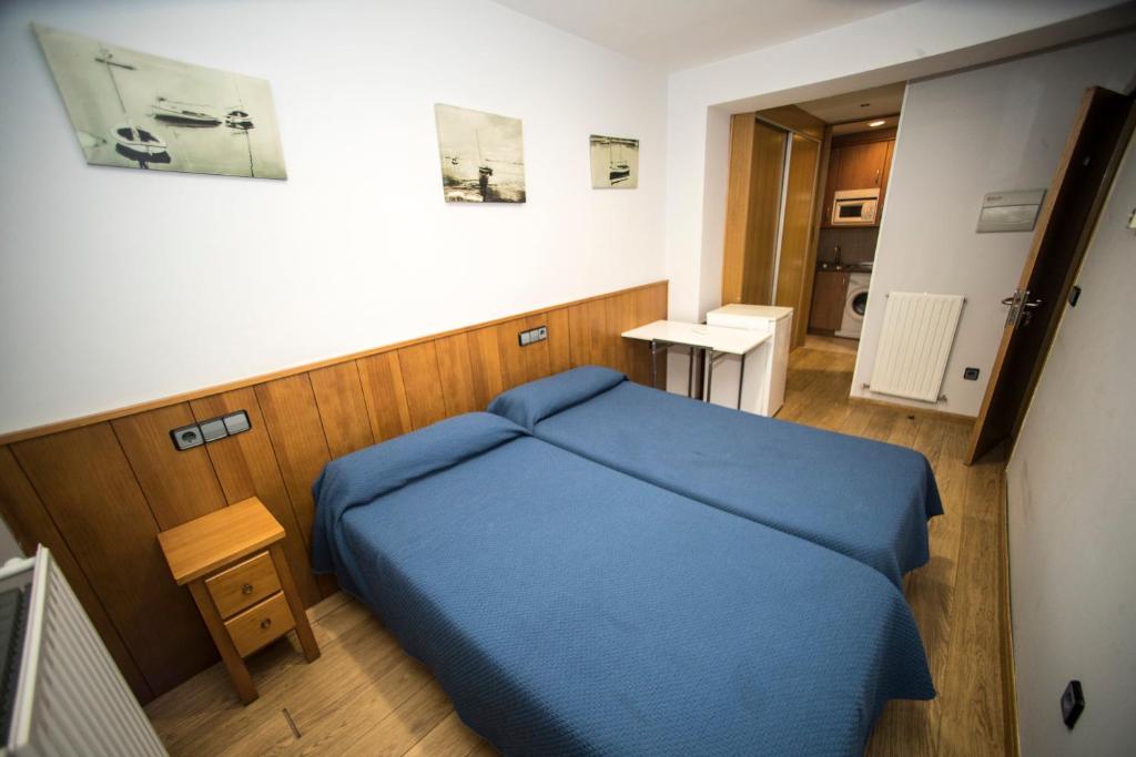 索里亚Hostal Caballeros的一间小卧室,房间内设有一张蓝色的床