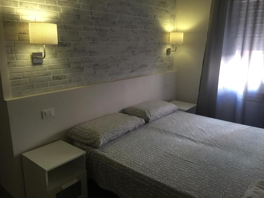 博洛尼亚Bologna Centrale Stanze的一间卧室设有一张床和砖墙