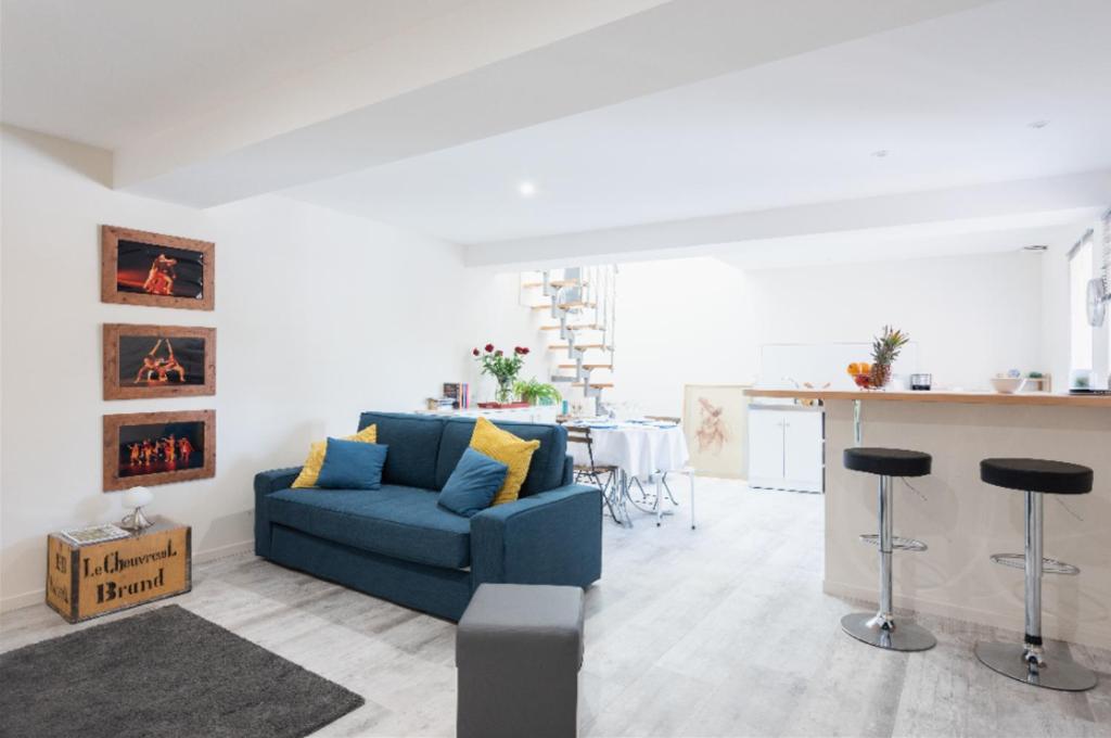 索恩河畔自由城Grand duplex au calme en centre-ville的一间带蓝色沙发的客厅和一间厨房