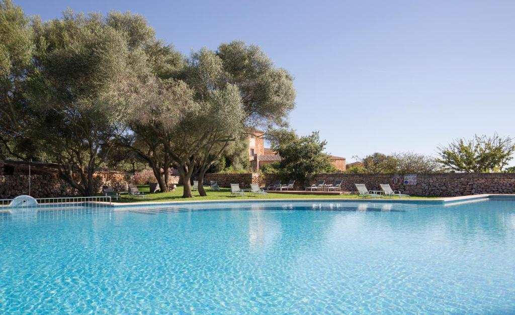 坎波斯索恩科斯梅特酒店的一个种有树木的大型蓝色游泳池