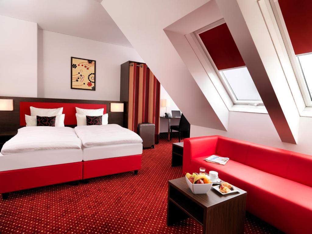 维也纳维也纳爱米迪亚贝斯特韦斯特优质酒店的酒店客房,配有一张床和一张红色的沙发