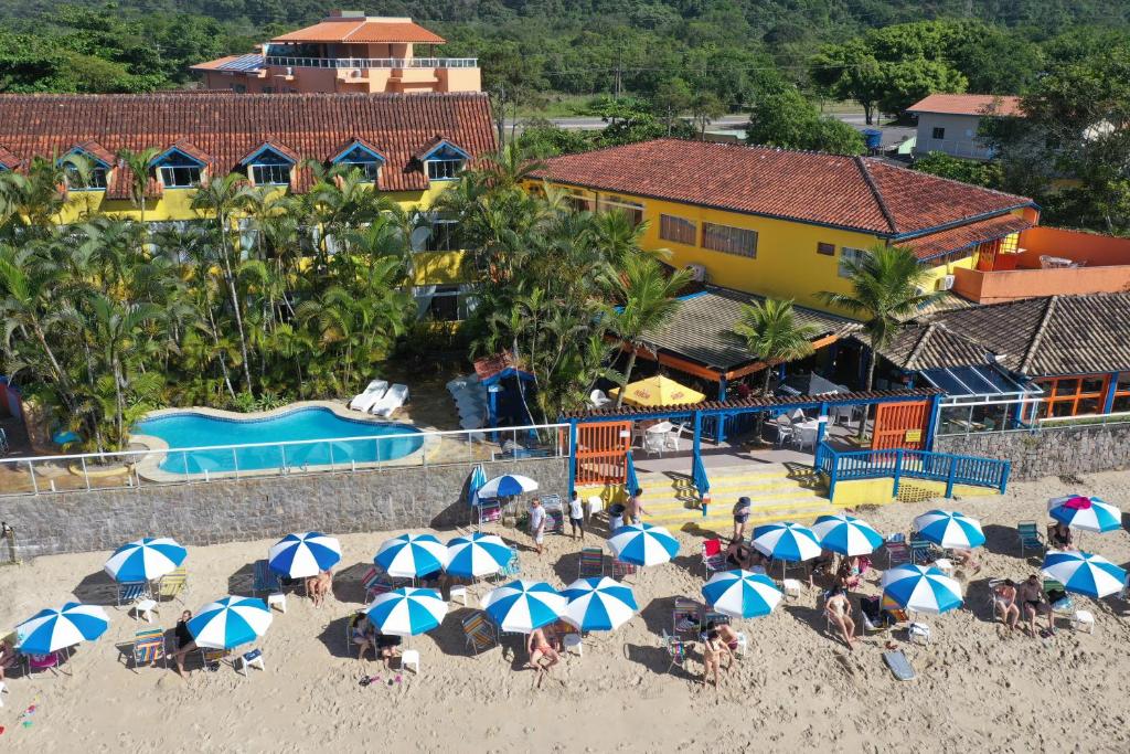 乌巴图巴卡里曼宾馆的一群人坐在海滩上,拿着遮阳伞