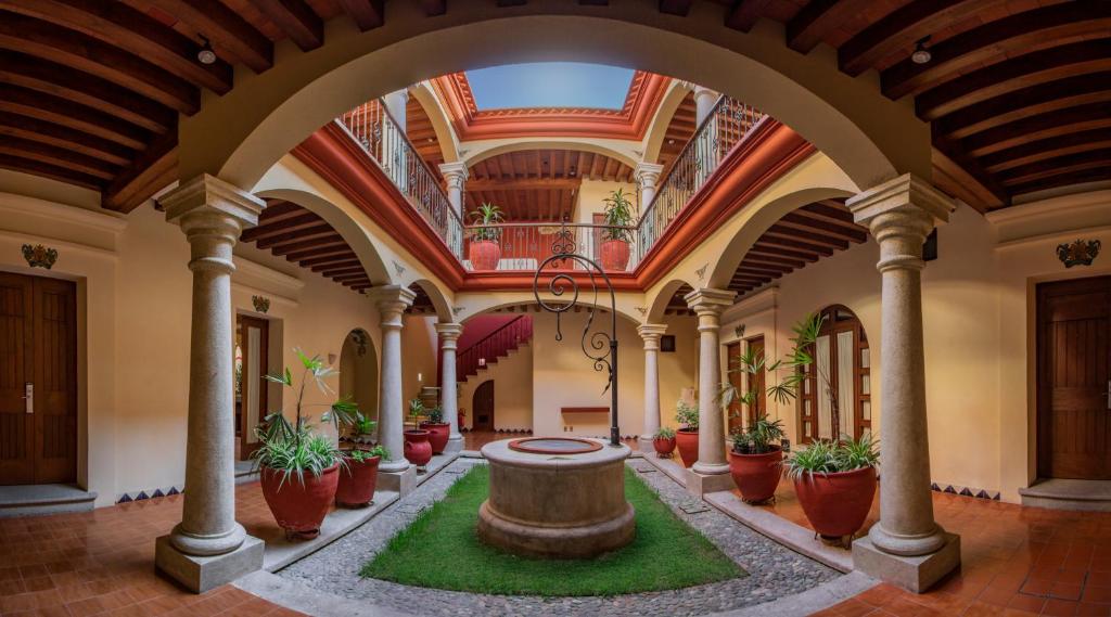 瓦哈卡市Hotel Casa Barrocco Oaxaca的大楼中央带喷泉的大走廊
