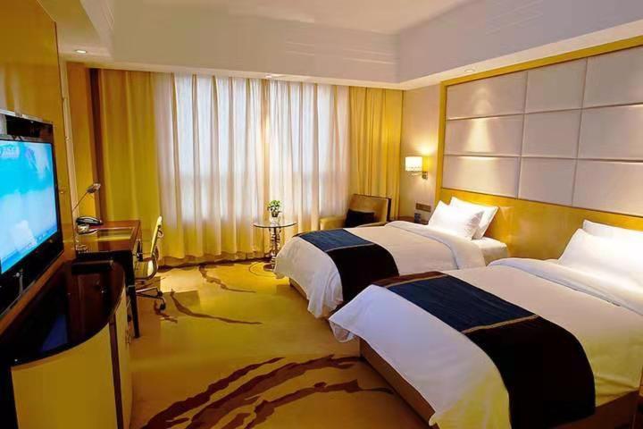 南京南京拉斐酒店禄口机场店的酒店客房设有两张床和一台平面电视。