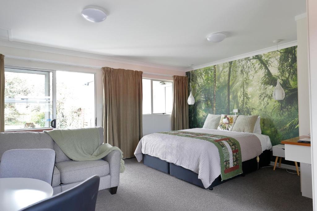 蒂阿瑙亚丁汽车旅馆的一间卧室配有一张床、一张沙发和一把椅子