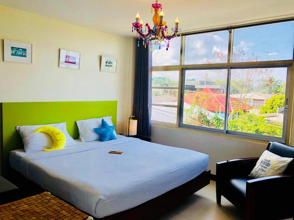 华欣Baan Nilawan Hua Hin Hotel的一间卧室配有一张大床和一个吊灯。