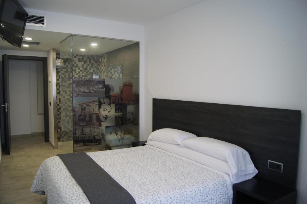 菲格拉斯Hostal Sanmar的一间卧室配有一张大床和镜子