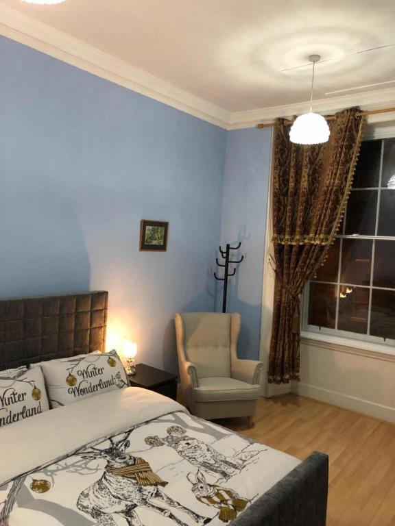 爱丁堡City Centre En-Suite Room的卧室配有床、椅子和窗户。