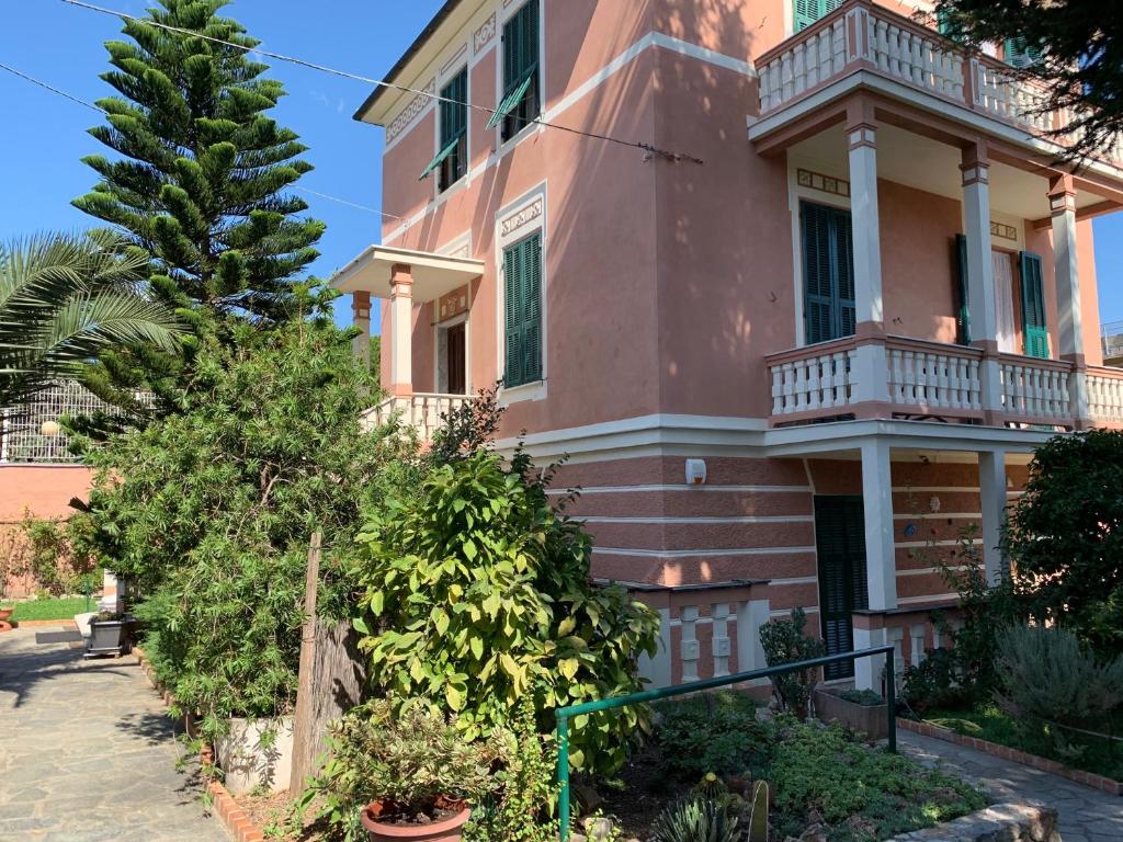 萨沃纳Resort Villa Rosa Maria的粉红色的房子,在街上设有阳台
