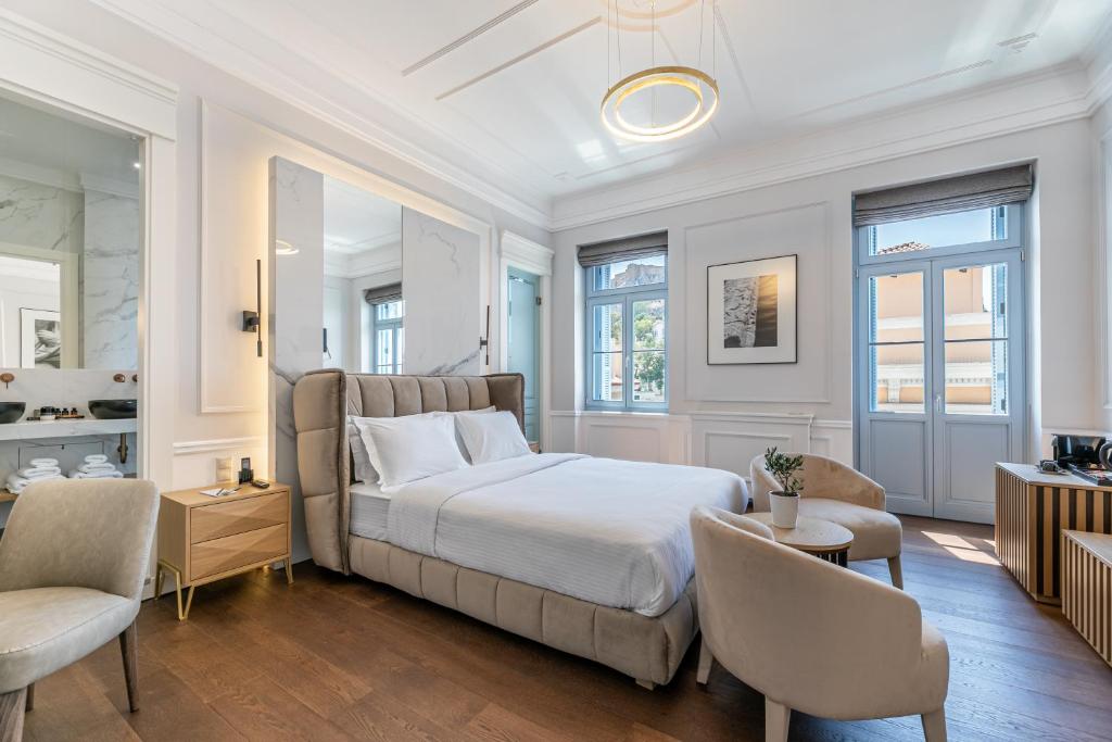 雅典A77 Suites的一间卧室配有一张大床和两把椅子