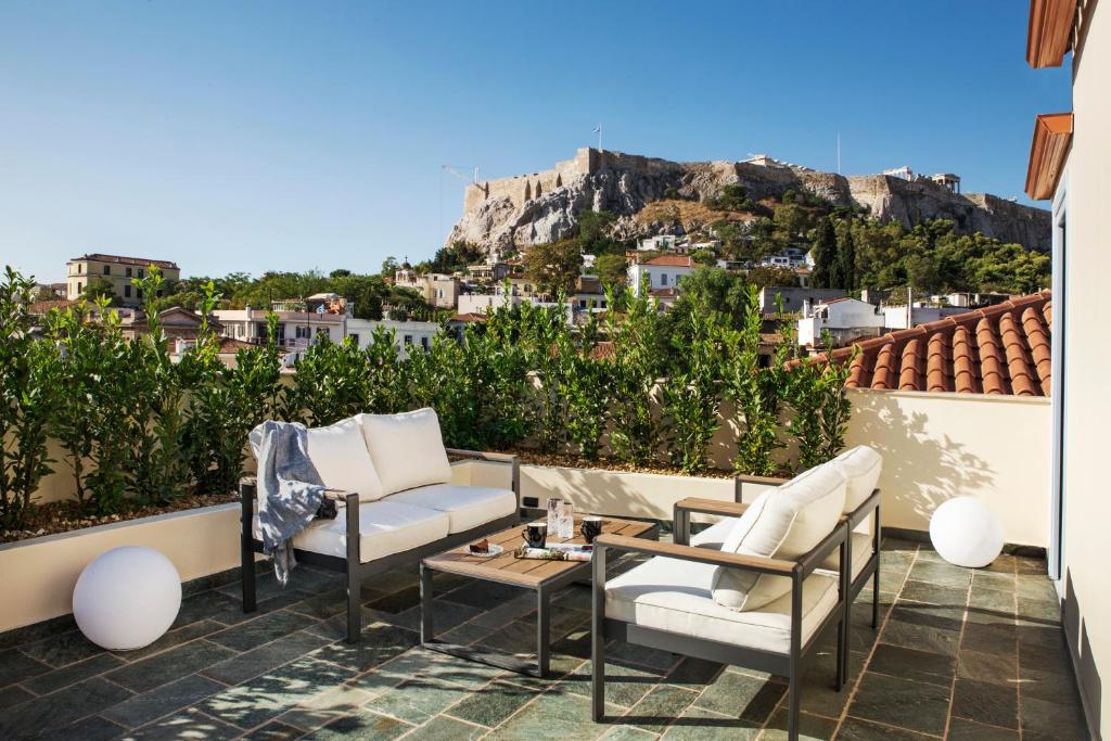 雅典A77 Suites的一个带两把椅子和一张桌子的庭院