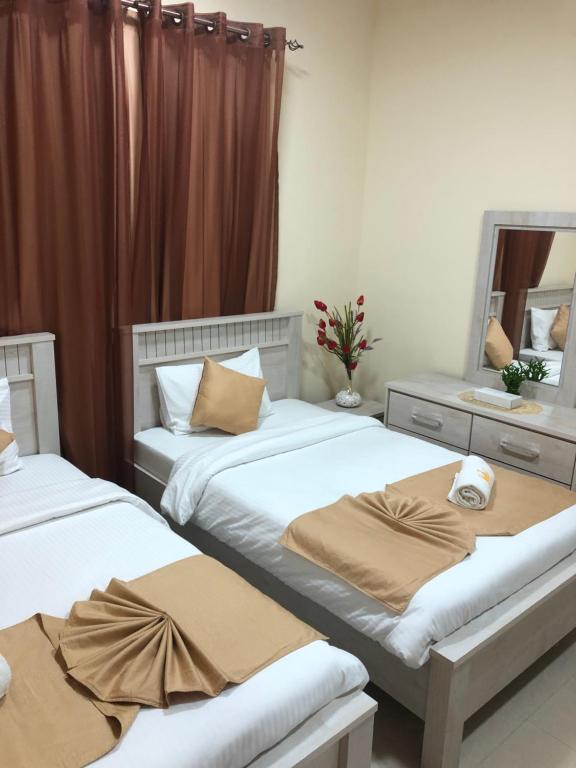 阿吉曼Al Khaleej Plaza Furnished Apartments LLC的卧室设有两张单人床和窗帘
