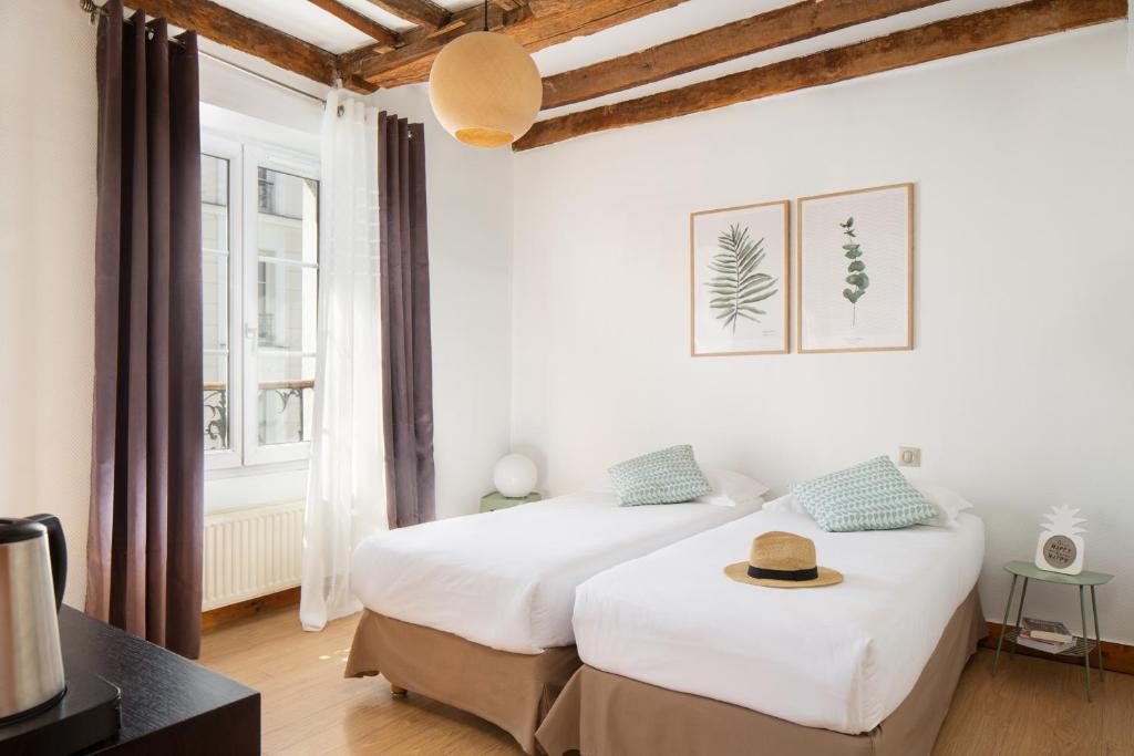 巴黎蒙马特村嘻哈旅舍的白色墙壁客房的两张床