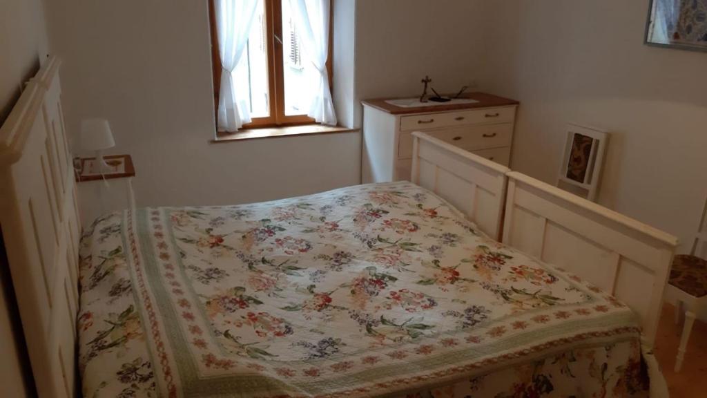卡斯泰洛泰西诺Appartamento Castello Tesino的一间卧室配有一张带鲜花毯子的床