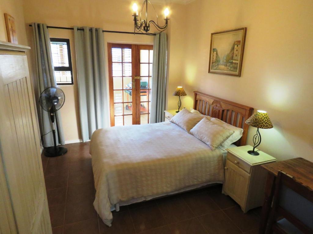 干斯拜Gansbaai Central Accommodation的一间卧室设有一张大床和一个窗户。