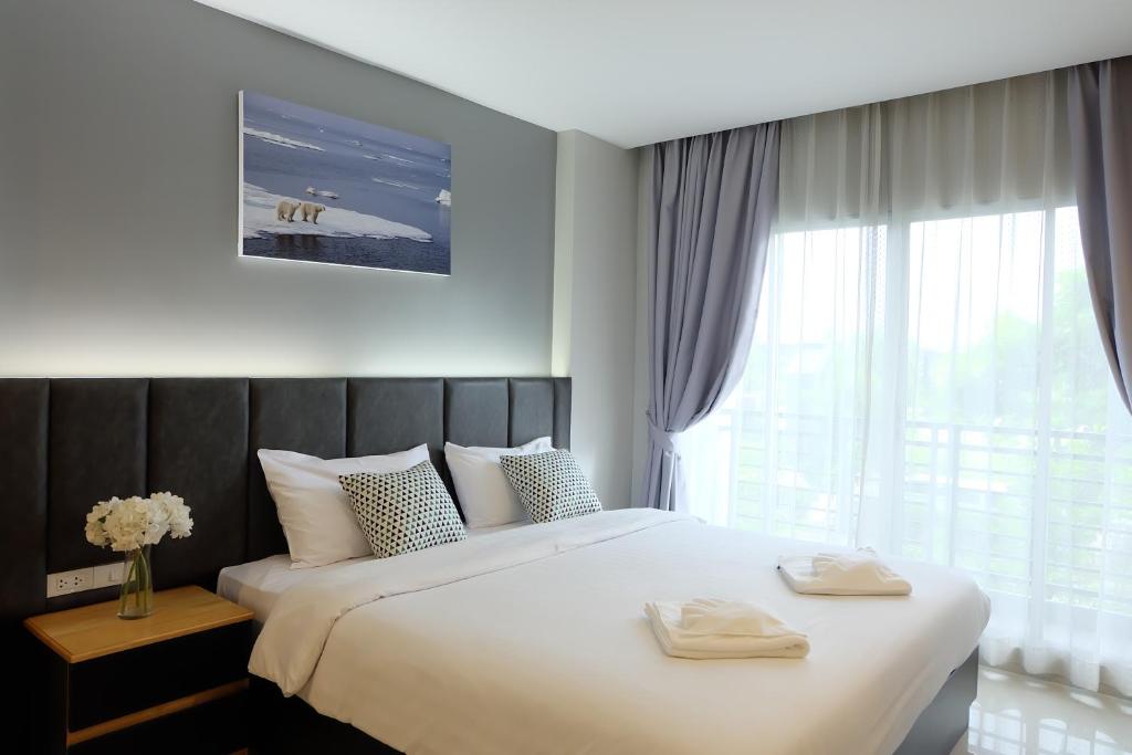 Ban Phan Sadet NokInterpark Hotel & Residence, Eastern Seaboard Rayong的一间卧室配有一张大床和两条毛巾