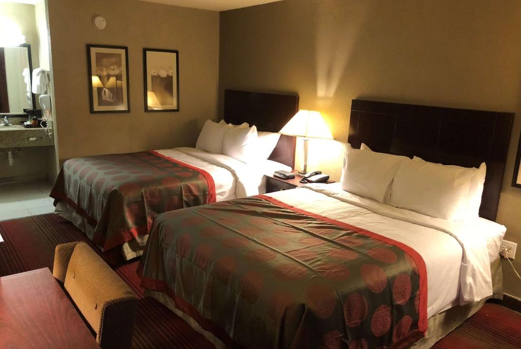 密歇根城Ramada by Wyndham Michigan City的酒店客房,设有两张床和一盏灯