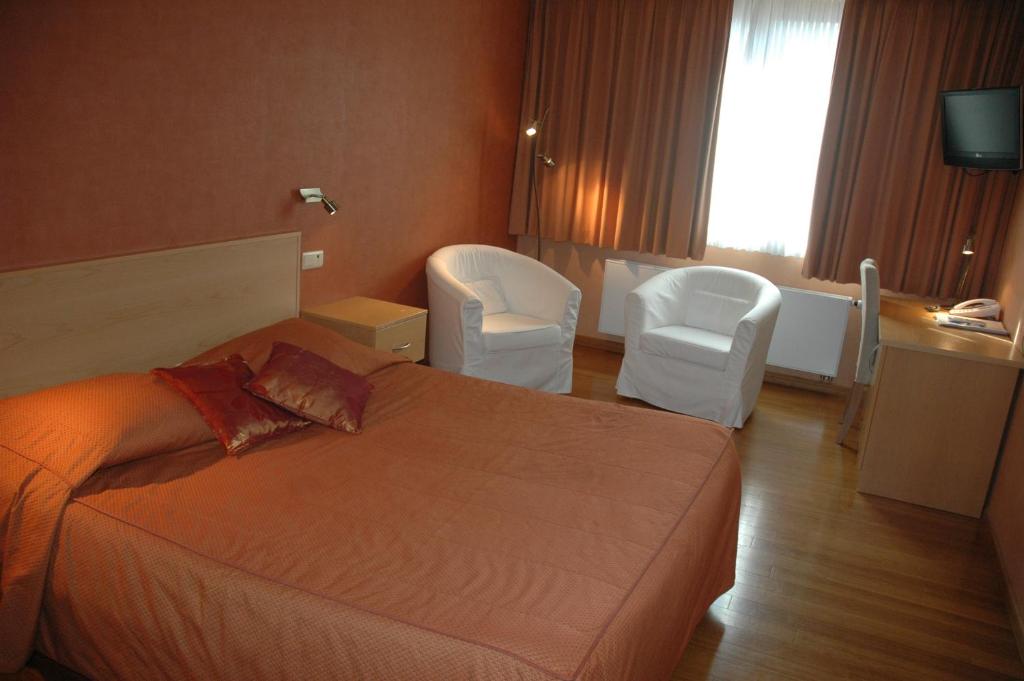 伊特尔勒瑞拉斯杜马奎斯酒店的酒店客房,配有一张床和两把白色椅子
