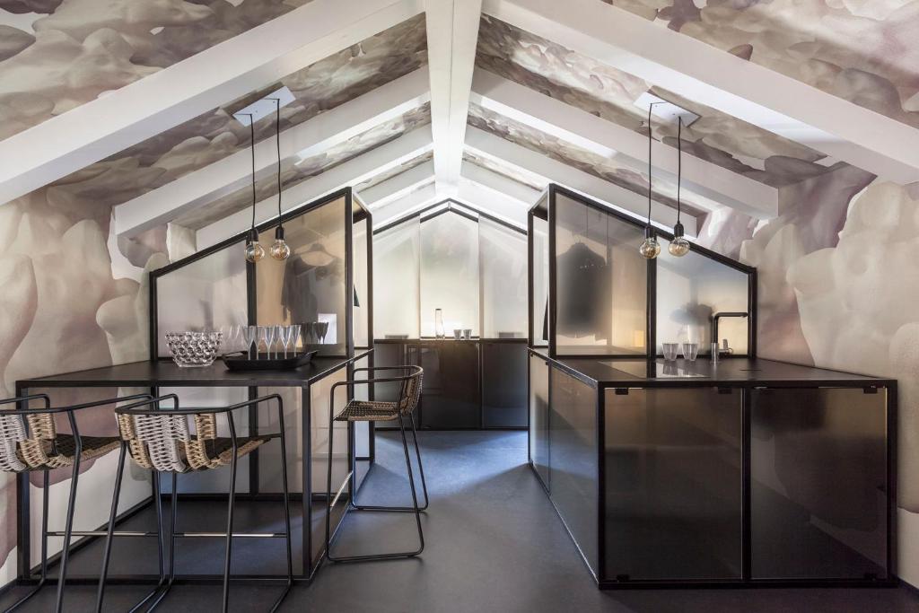 特伦托Casa Trentini - Atemporary Art Apartments的一间设有黑桌椅和天花板的客房