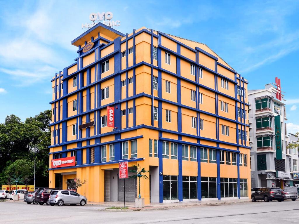 莎阿南Super OYO 258 Hotel SMC Alam Avenue的街道上一座蓝色装饰的黄色建筑