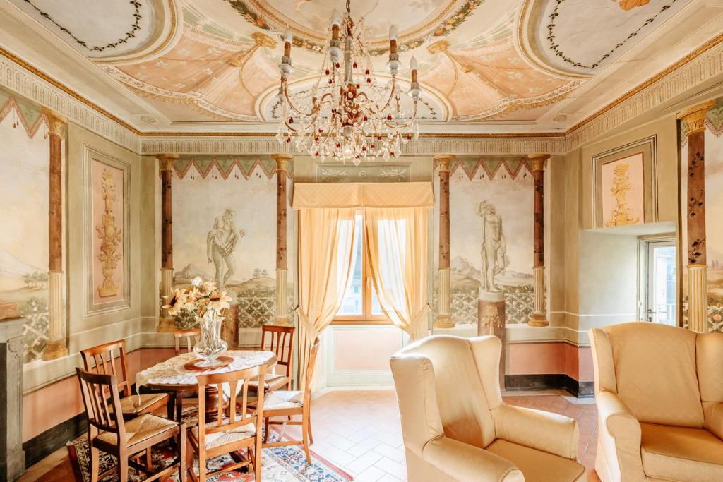 罗洛·丘芬纳狄莫拉卡萨尤金妮亚酒店的一间带桌椅和吊灯的用餐室