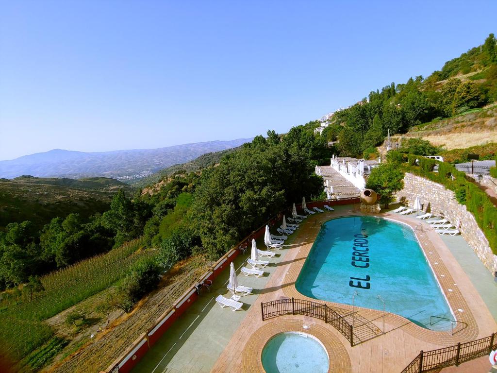 贝尔楚勒斯Turismo Rural & SPA El Cercado的享有带躺椅的游泳池的空中景致